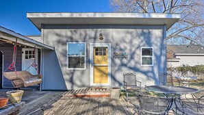 A small house with a porch, a swing, a welcome sign, and a table with chairs. - 1 Mi to Dtwn Rogers: Convenient Getaway w/ Patio (Rogers)