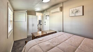 A bedroom with a bed, a desk, and a wardrobe. - 1 Mi to Dtwn Rogers: Convenient Getaway w/ Patio (Rogers)