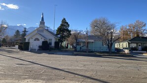 A church with a steeple, surrounded by residential buildings and a clear sky. - Comfy Bungalow (Lone Pine)