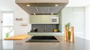 A modern kitchen with a central island, a microwave, and a coffee maker.