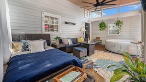 A bedroom with a bed, a ceiling fan, a window, and a view of the outside. - Birdhouse: Pet friendly 2 Bed With Yard & Hot Tub (Charleston)