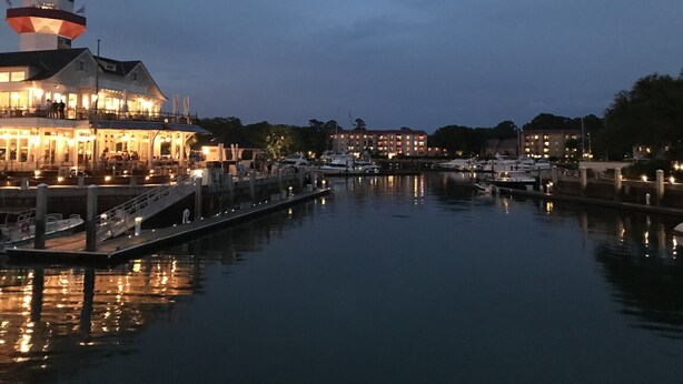 A waterfront hotel with a prominent lighthouse, a dock with boats, and a calm marina. - Easy Beach Living – Single-Story Coastal Retreat - 5-Minute Walk to the Beach (Hilton Head Island)
