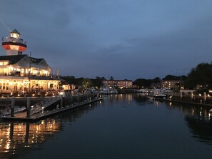 Un hôtel situé au bord de l’eau, doté d’un phare imposant, d’un quai avec des bateaux et d’une marina paisible.