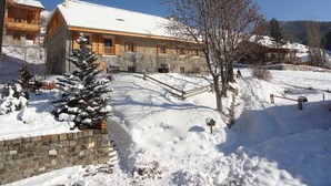 A stone building with a snow-covered roof and wooden balconies. - Exceptional and spacious apartment – Coup de Cœur – in the heart of the resort (Vars)