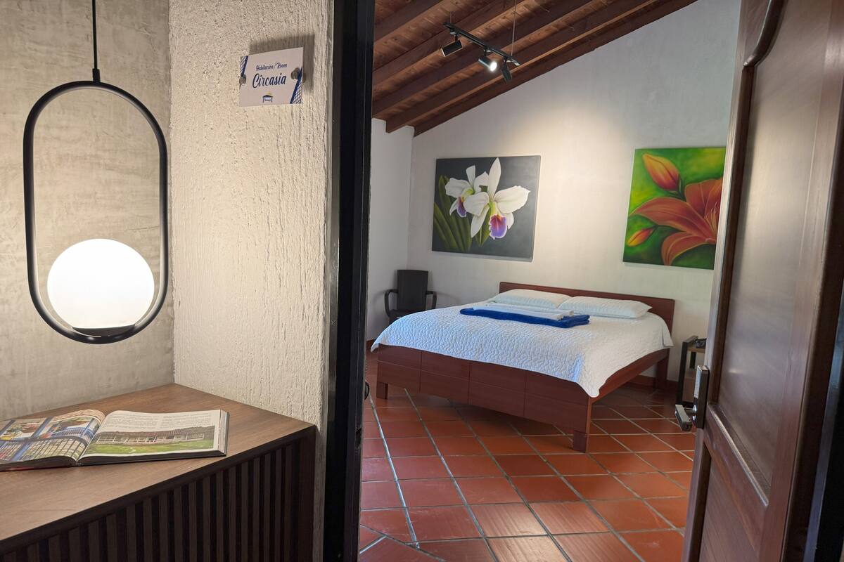Ein Schlafzimmer mit Bett, Nachttisch, Fenster und Tür.