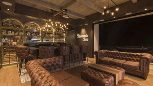 A bar area with leather sofas, a bar counter, and a neon sign reading "Hermania Bar". - Chalet La Alemania (Calarcá)