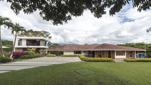 A modern two-story house with a tiled roof and a well-maintained lawn. - Chalet La Alemania (Calarcá)