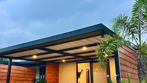 A modern house with a wooden deck, a glass door leading inside, and a small outdoor seating area. - Chalet La Alemania (Calarcá)