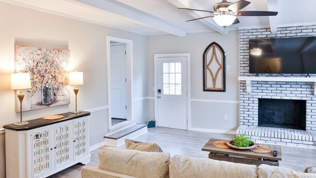 A living room with a fireplace, a sofa, a coffee table, and a TV.