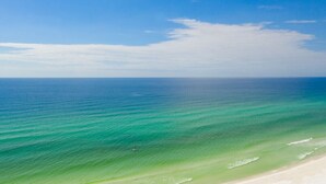 Een strand met helder turquoise water en een zandkust.