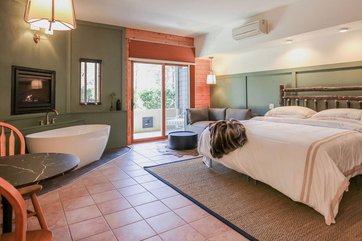 Ein Schlafzimmer mit einem großen Bett, einer Badewanne und einem Esstisch.