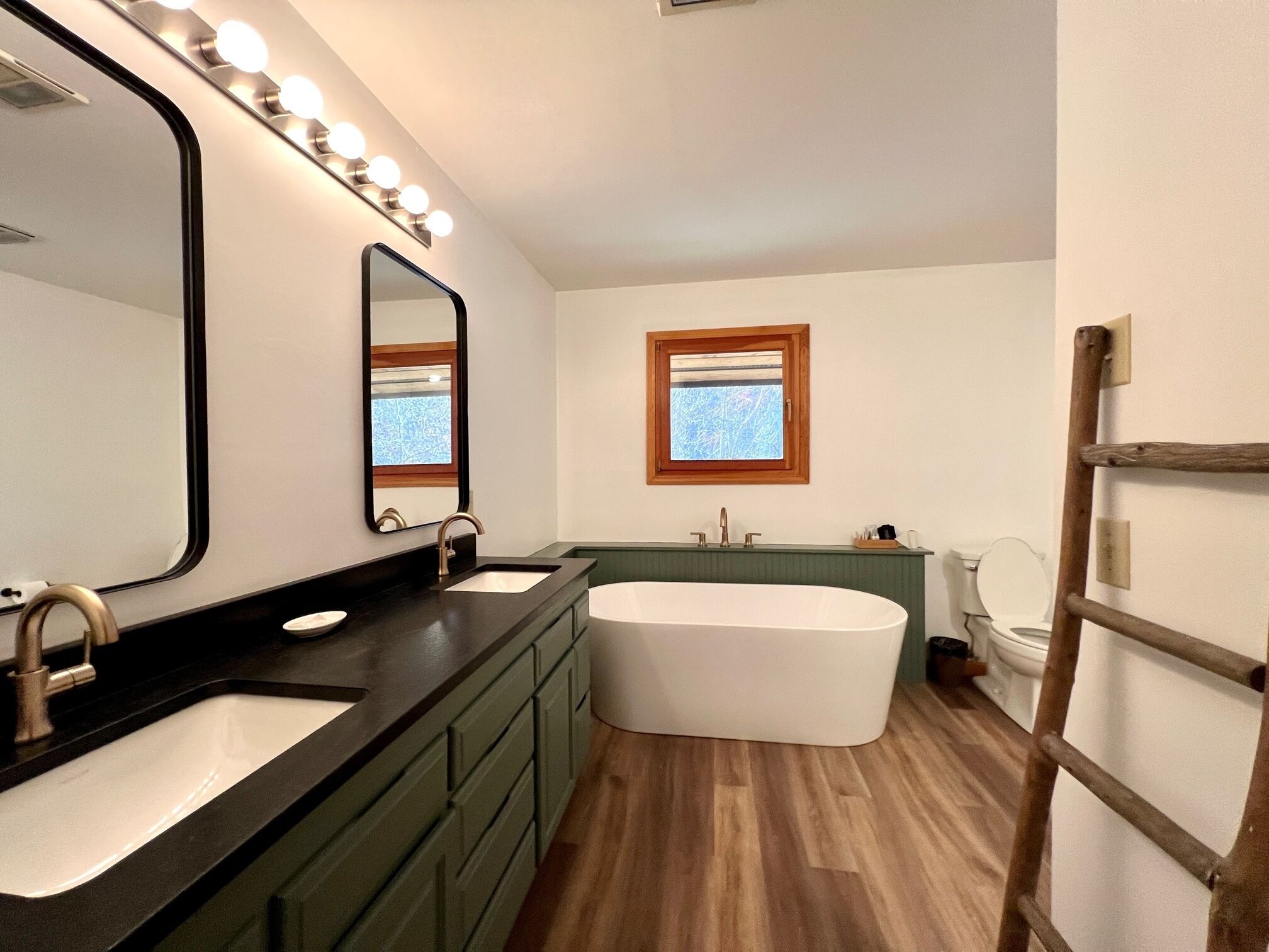 A bathroom with a vanity, a bathtub, and a toilet.