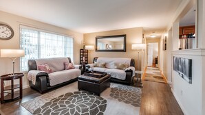 A living room with two sofas, a coffee table, a rug, and a large window. - Cozy Home in the Heart of Corvallis (Corvallis)