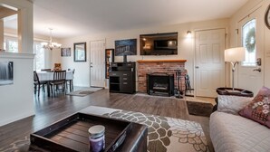 A spacious living area with a fireplace, a dining table, and a sofa. - Cozy Home in the Heart of Corvallis (Corvallis)