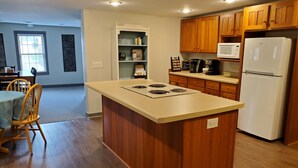 A kitchen with wooden cabinets, a white refrigerator, a microwave, and a coffee maker.