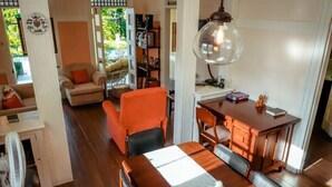 Una sala de estar acogedora con comedor, una mesa de madera y un ventanal grande.