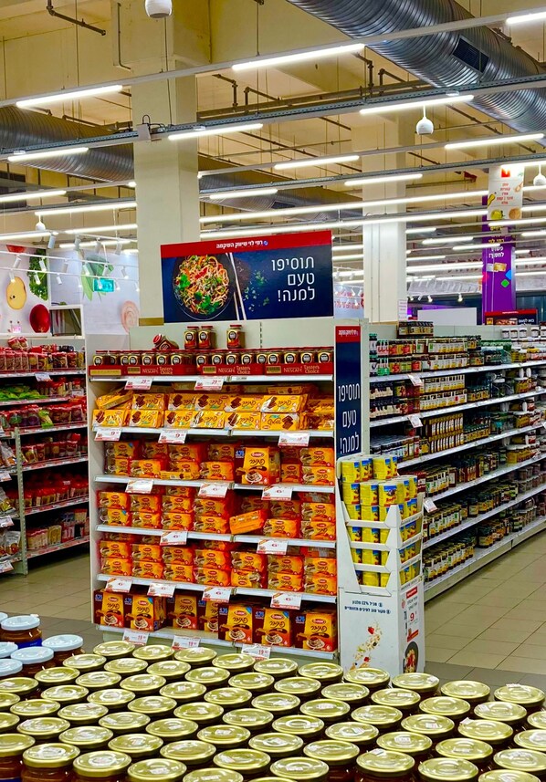 Un rayon de supermarché avec des étagères remplies de divers produits alimentaires, notamment des produits emballés et des bocaux.