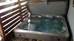 A hot tub with a wooden deck surrounding it. - Govy A Frame w/ Hot Tub. (Government Camp)