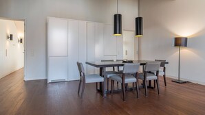A modern dining area with a rectangular table, six chairs, and pendant lighting. - 8 Building Apartment 403 [T2] - River & Garden View (Lisboa)