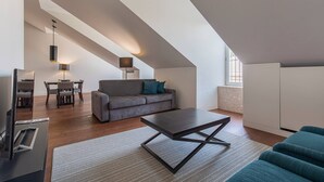 A modern living room with a sofa, coffee table, and dining area. - 8 Building Apartment 403 [T2] - River & Garden View (Lisboa)