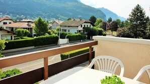 Un balcón con vistas a una zona residencial y montañas.