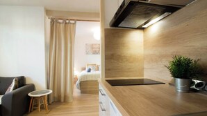Una cocina moderna con armarios de madera, estufa integrada y una pequeña mesa redonda.