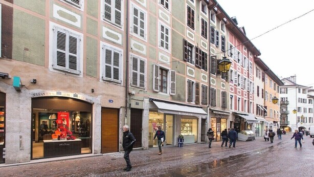 A cobblestone street with historic buildings, storefronts, and pedestrians. - Cocoon 1 min romantique (Annecy)