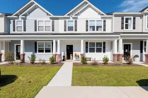 A two-story residential building with a symmetrical facade, brick accents around the windows, and a central entrance. - Charlie's House -8 min.to Historic Summerville/30 min to Charleston and Airport (Summerville)