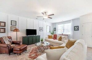 A living room with a sofa, armchair, coffee table, and a television. - Charlie's House -8 min.to Historic Summerville/30 min to Charleston and Airport (Summerville)