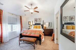 A bedroom with a bed, a bench, a dresser, a mirror, and a ceiling fan. - Charlie's House -8 min.to Historic Summerville/30 min to Charleston and Airport (Summerville)