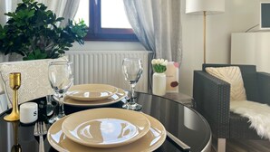 A dining table set with plates, glasses, and cutlery, a vase with flowers, and a lamp. - Mount Royal balcony with mountain view (Annecy)