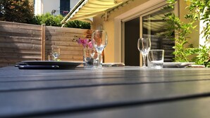 Ein Tisch im Freien mit Weingläsern, einem Laptop und einem Smartphone.
