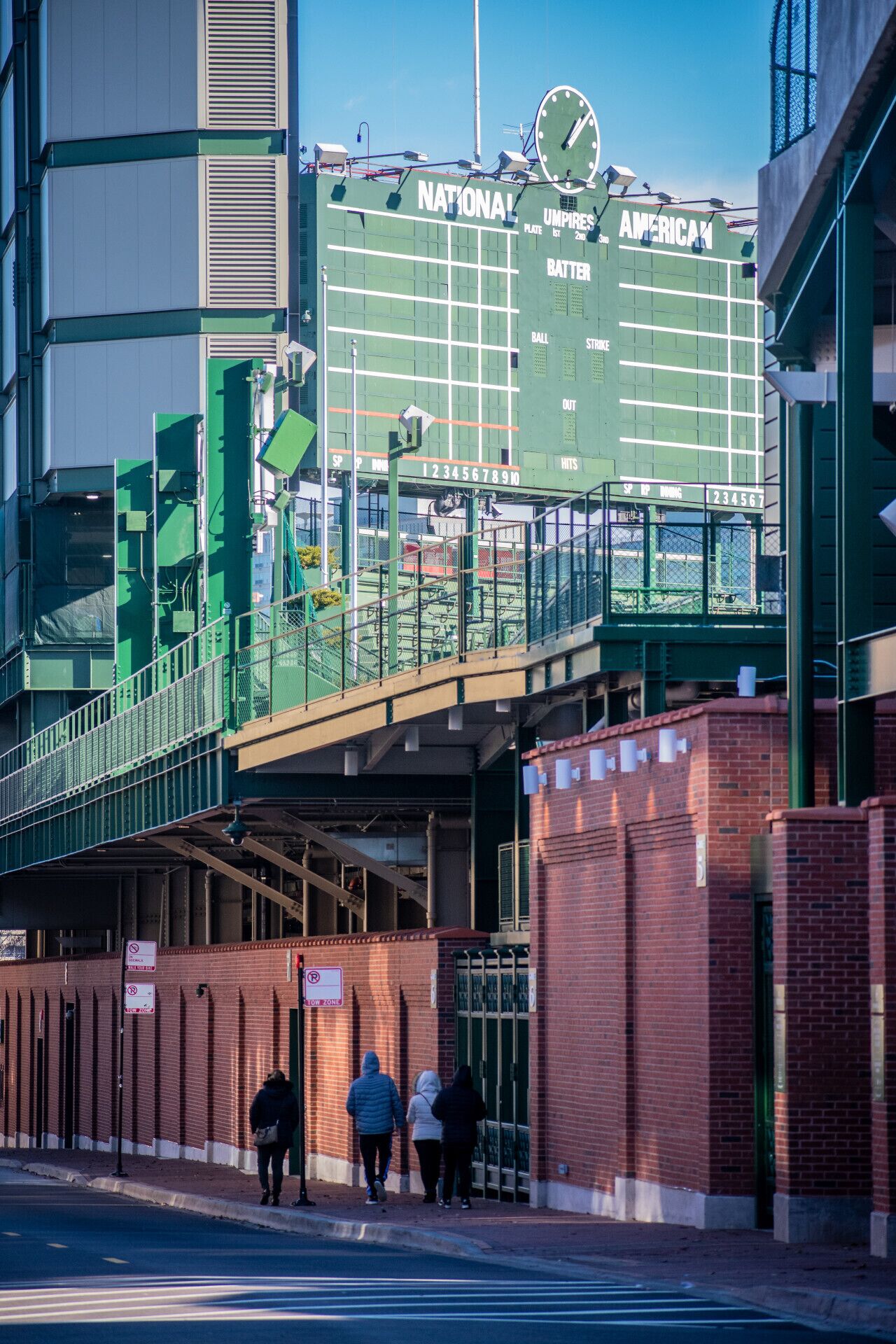 A baseball stadium with a scoreboard and a pedestrian bridge.
