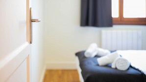 Une chambre d’hôtel avec un lit, une fenêtre avec des rideaux et un radiateur.