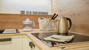 Una cucina con un piano di lavoro, un bollitore, un frullatore e un portacoltelli.