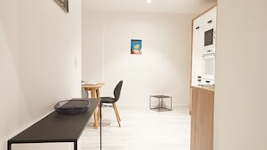 Una cucina moderna con mobili bianchi, forno integrato e zona pranzo con tavolo e sedie.