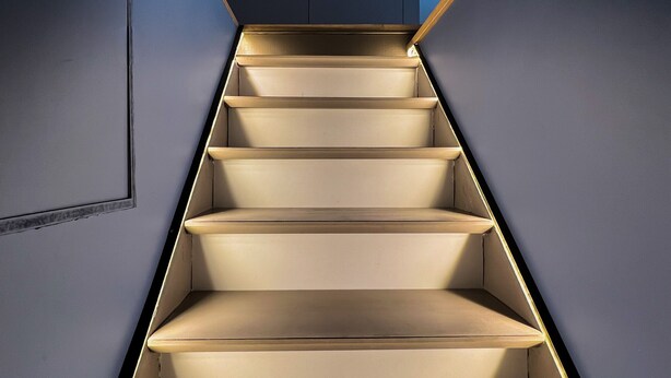 Un escalier au design moderne, avec une palette de couleurs dans les tons beige et un motif géométrique sur les murs.