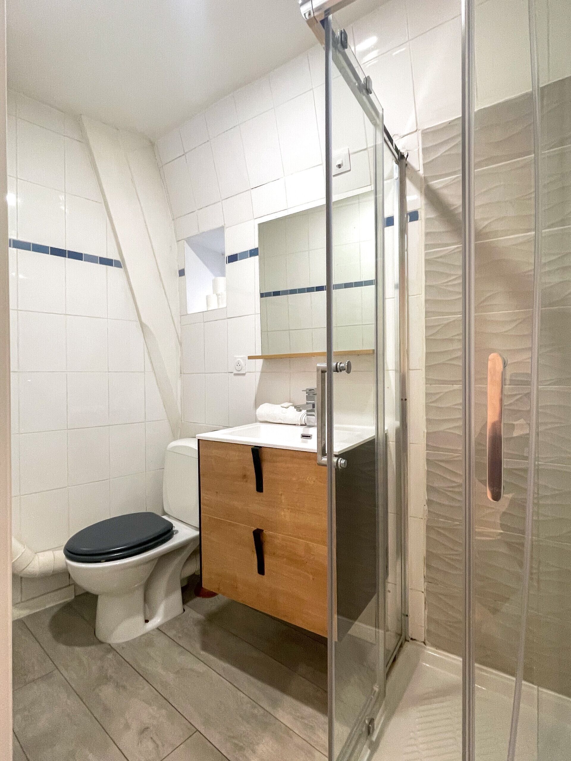 A modern bathroom with a toilet, sink, and shower area.