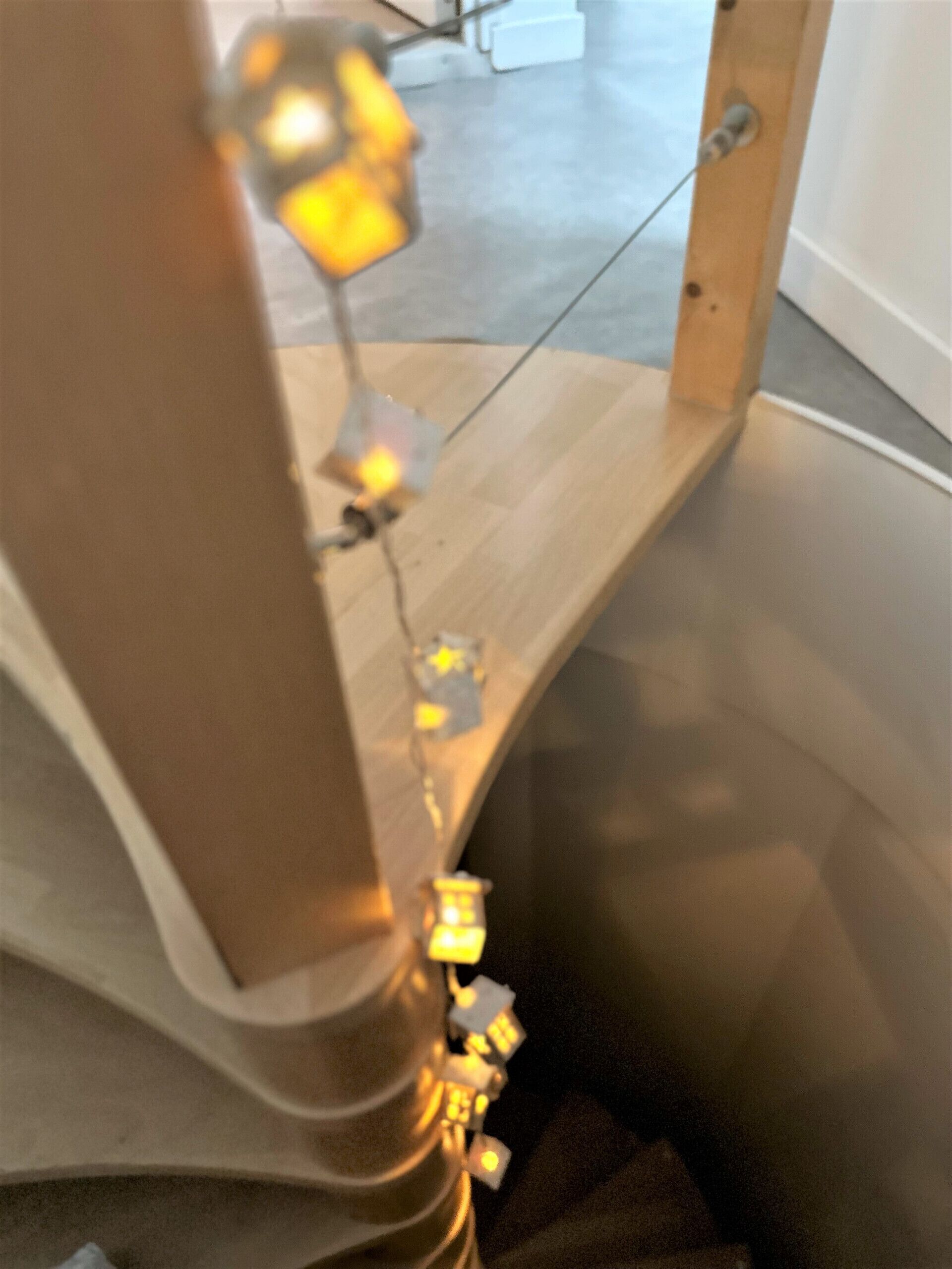 A staircase with a wooden handrail and a metal banister.