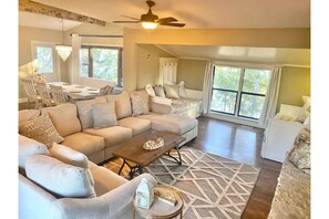 Relax in this inviting living area with a large L-shaped sofa, coffee table, and dining table.