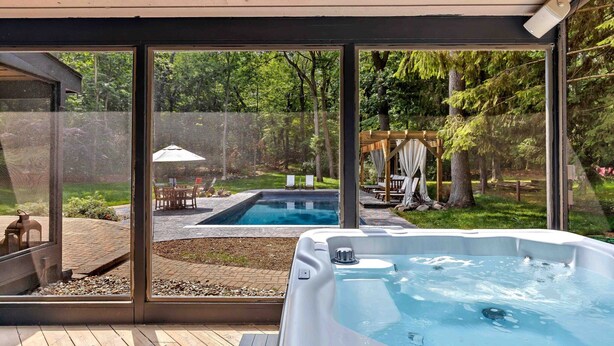 Un área moderna de hidromasaje al aire libre con piscina y mobiliario de patio.