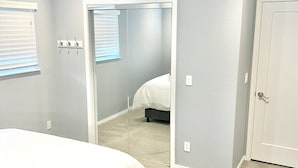 A bedroom with a bed, a ceiling fan, a door, and a window with blinds. - Lake View! Hot-Tub! Beaver Lake House! (Rogers)