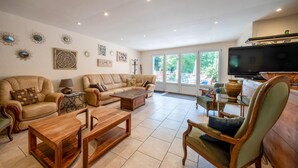 A spacious living room with a large sofa set, a wooden coffee table, and a television. - Pet friendly home in Escles with WiFi (Escles)