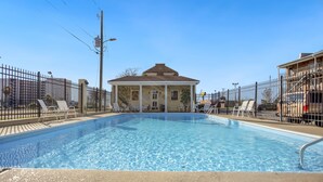 A swimming pool with a building in the background. - Edgewater Inn (Biloxi)