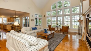 A spacious living room with a large sofa set, a coffee table, and a fireplace. - Beautiful New Seabury Home in Mashpee (Mashpee)