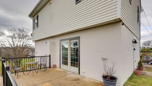 Una casa con patio, puerta corrediza de vidrio y mobiliario exterior.