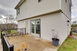 Ein Haus mit Terrasse, einer Glastür und Gartenmöbeln.