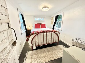 Cozy retreat with a single bed, bedside table, and window offering a view of the outdoors.