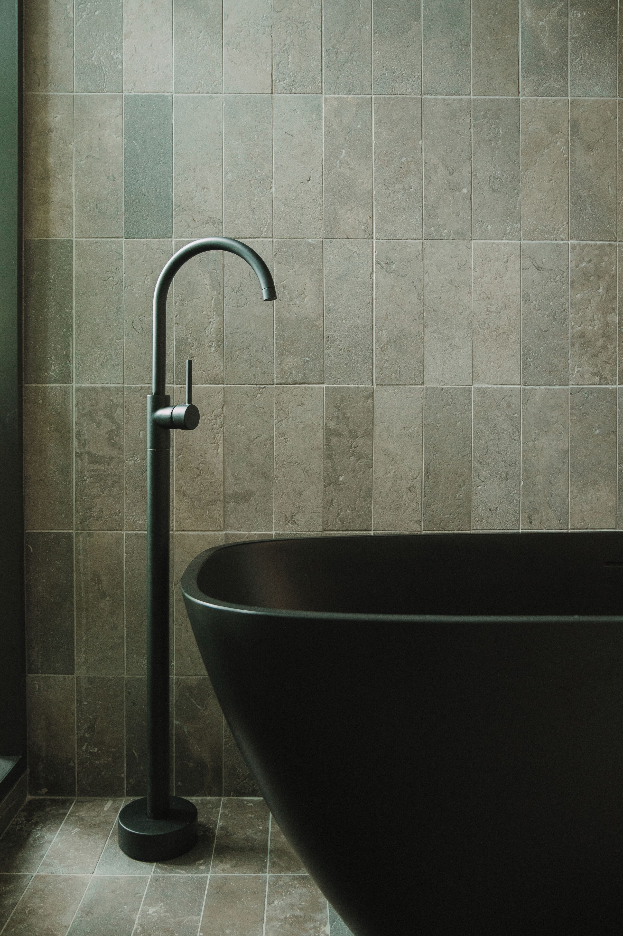 A modern bathroom with a freestanding bathtub and a wall-mounted faucet.