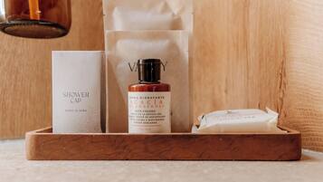 A wooden tray with a bottle of cream, a white box, and a white package.